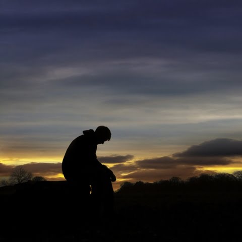 Sad man sitting in sunset